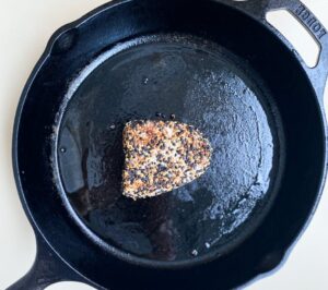 Searing sesame crusted ahi tuna in cast iron pan