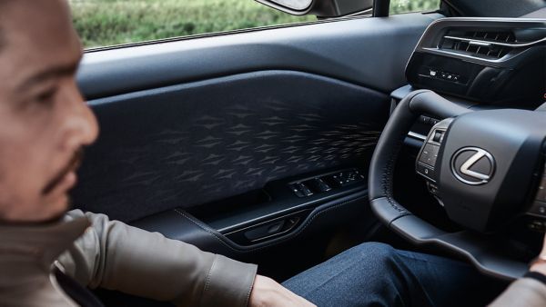 A man sat in the drivers seat of a Lexus RZ 450e