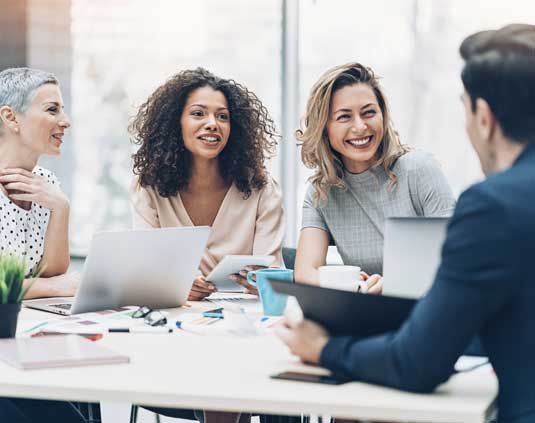 Three women conduct an interview for an open creative executive staffing position