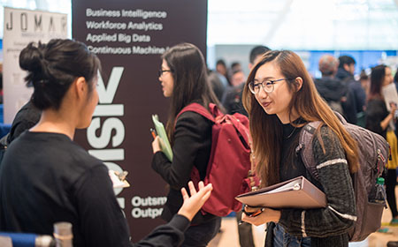 A student meets an employer at a career fair