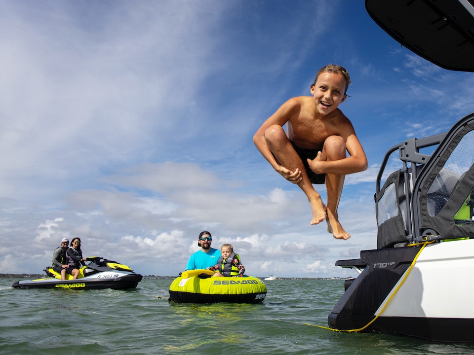 Kid jumping in the water from a Sea-Doo Switch pontoon