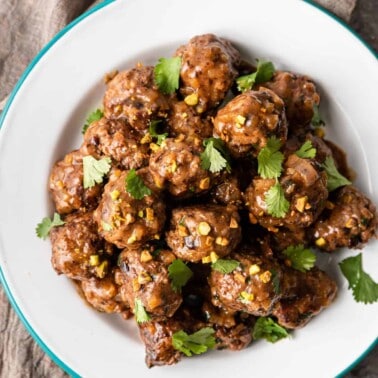 overhead: homemade lamb meatballs on a white plate