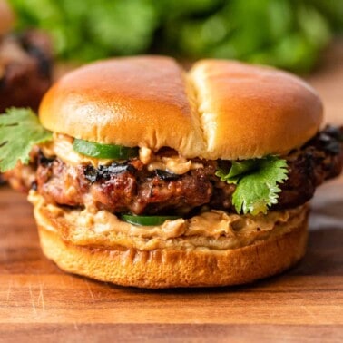 ground pork and beef burger with jalapenos and spicy peanut sauce on soft bun