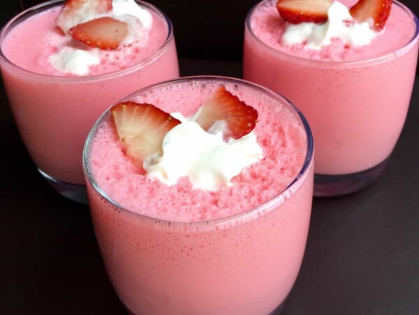 3 glasses of strawberry yogurt fluff garnished with sliced strawberries