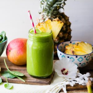 Detox island green smoothie in a mason jar with a paper straw.