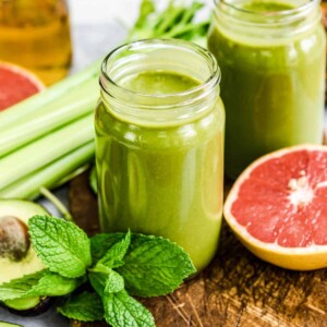 Two mason jars full of fat burning smoothies for weight loss, with ingredients around.