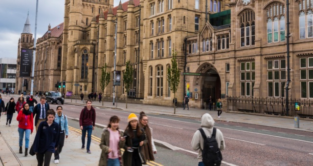 Students walking past the main University entrance on Oxford Road.