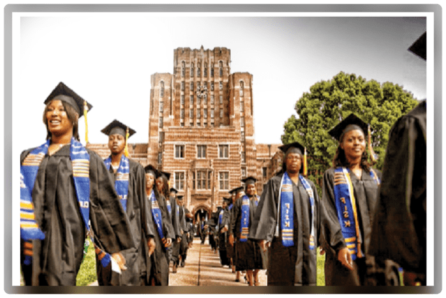 A group of people wearing graduation gowns and caps standing in front of a building.