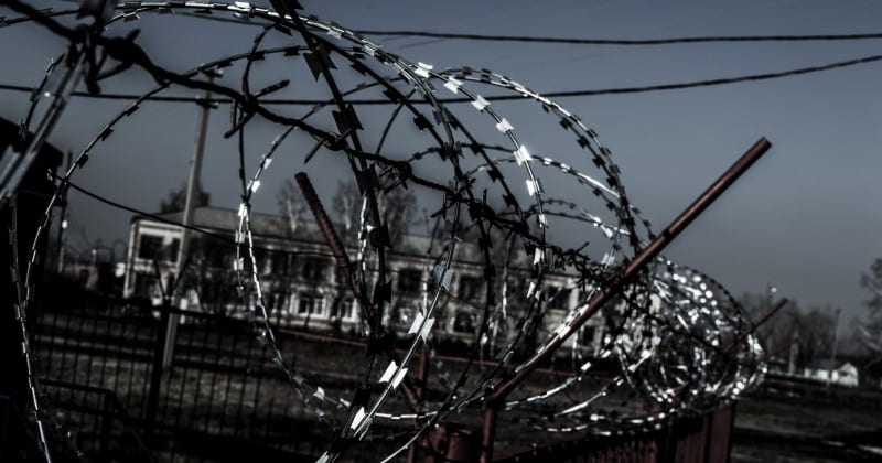 A barbed wire fence in front of a dusky sky