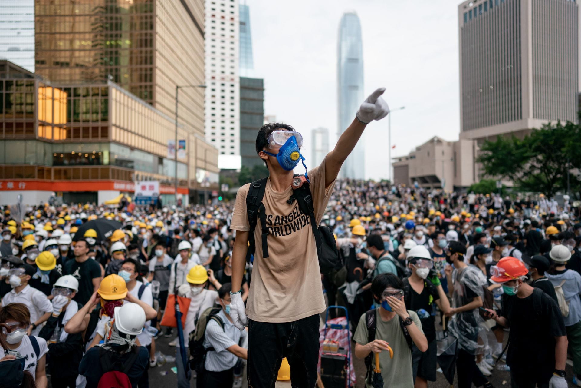 A man standing in front of Hong Kong protesters pointing out.