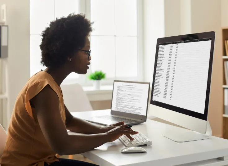 Young black female bookkeeper works on a computer crunching numbers