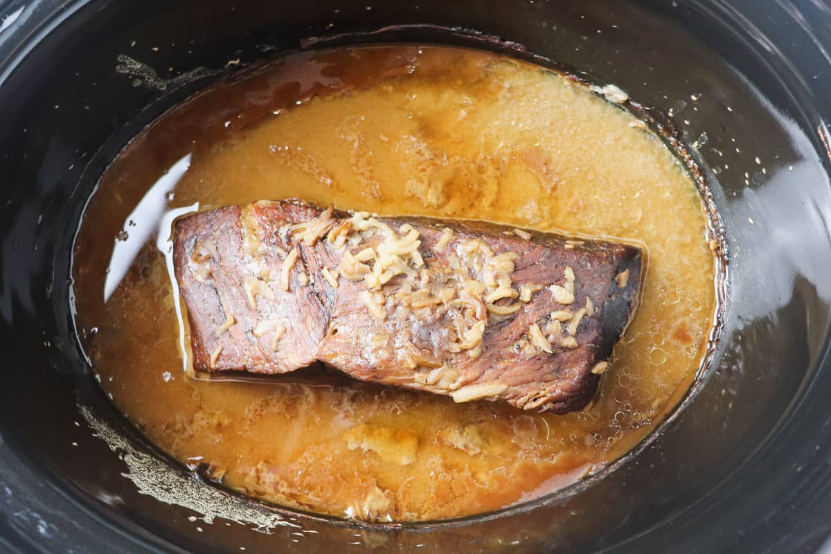 pot roast with gravy inside crock pot before shredding