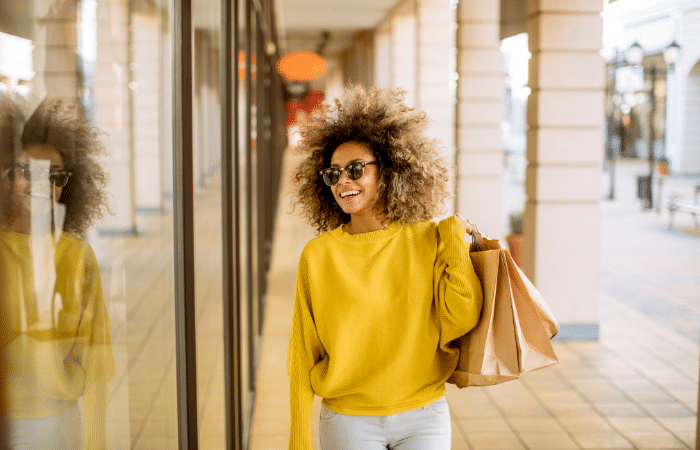 smiling woman, walking and holding shopping bags