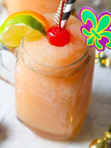 frozen hurricane mixed drink in a mason jar topped with a cherry