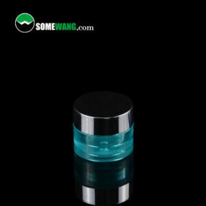 Un pot de crème PETG turquoise de 5 g et 15 g avec un capuchon foncé sur une surface noire réfléchissante, avec un texte en filigrane : "somewang.com" en haut.