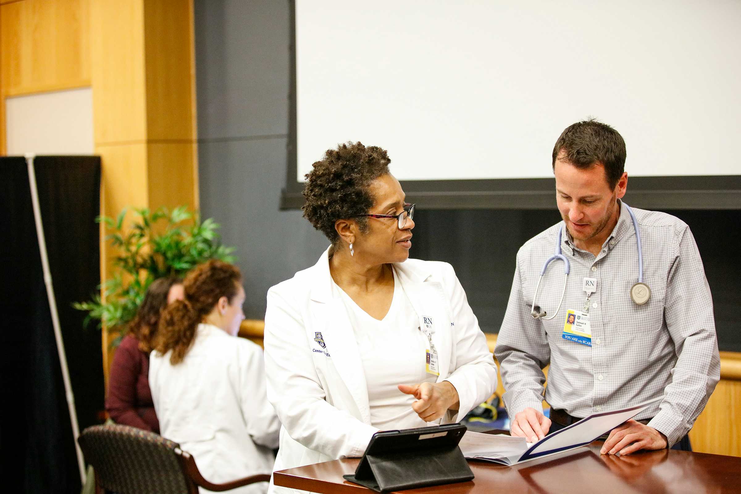 Nurse looking at biometric numbers with patient