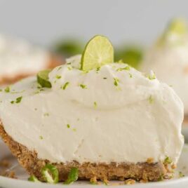 close up shot of a slice of pie garnished with lime on a plate