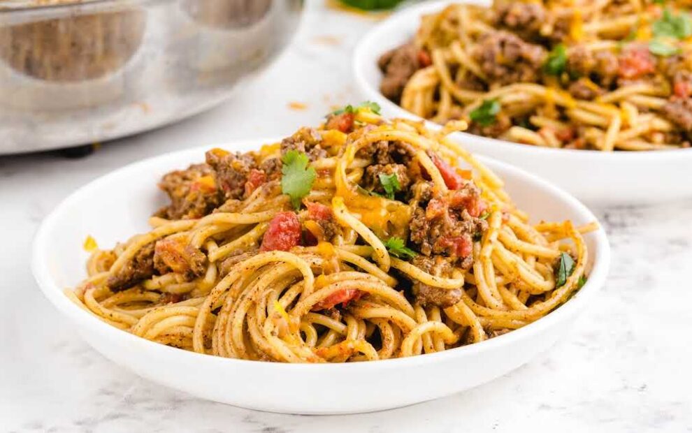 close up shot of a serving of Taco Spaghetti topped with cilantro on a plate