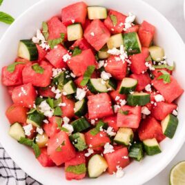 close up overhead shot of a serving of watermelon salad topped with mint leaves and feta cheese in a bowl