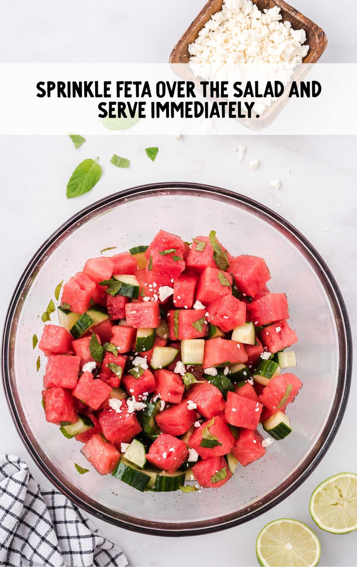 feta cheese being sprinkled over salad