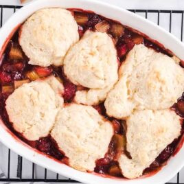 overhead shot of a Strawberry Rhubarb Cobbler cobbler in a baking dish placed on a cooling rack