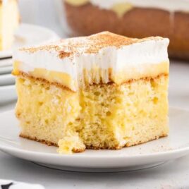 a close up shot of a slice of Eggnog Poke Cake on a plate