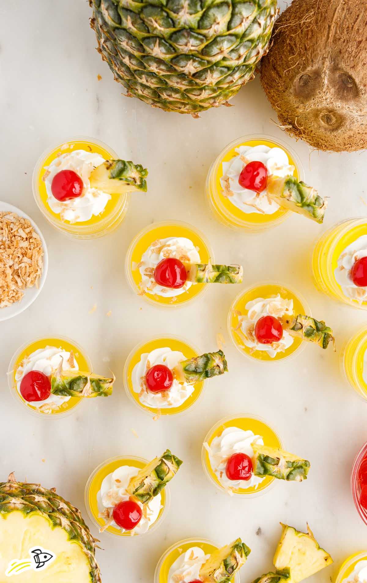 overhead shot of Pina Colada Jello Shots topped with cherry and a slice of pineapple