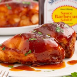 chicken topped with Sweet Baby Rays and garnished with parsley on a plate