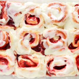 A glass baking dish is full of strawberry cinnamon rolls.