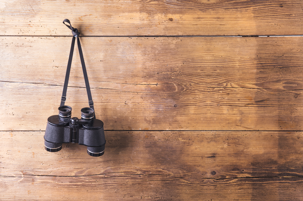 binoculars hanging on wooden fence