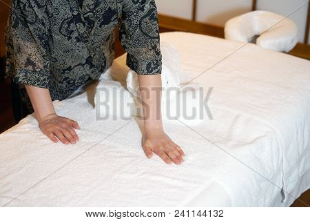 The Girl Prepares A Workplace Massage Bed In The Spa For The Reception Of Clients. The Maid Is Prepa