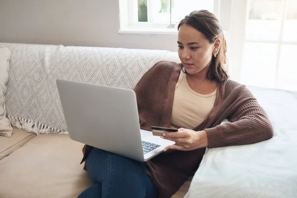 Shes not one to miss out on a deal. a young woman using a laptop and credit card at home