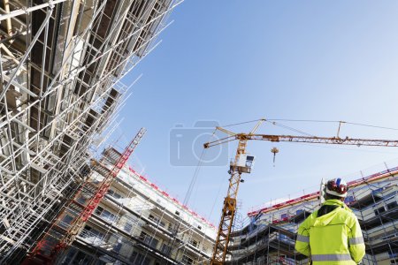 Foto de Topógrafo, ingeniero con instrumento de medición, trabajando dentro de la obra, perspectiva superamplia. pequeño texto rojo es solo el nombre de tablones
. - Imagen libre de derechos