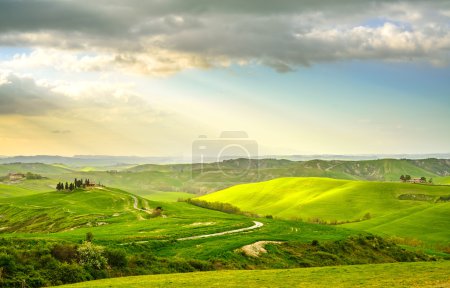 Foto de Toscana, paisaje rural al atardecer. Finca rural, cipreses, campo verde, luz solar y nubes. Volterra, Italia, Europa
. - Imagen libre de derechos