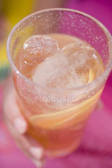 Closeup view of hand holding glass of iced tea — Stock Photo