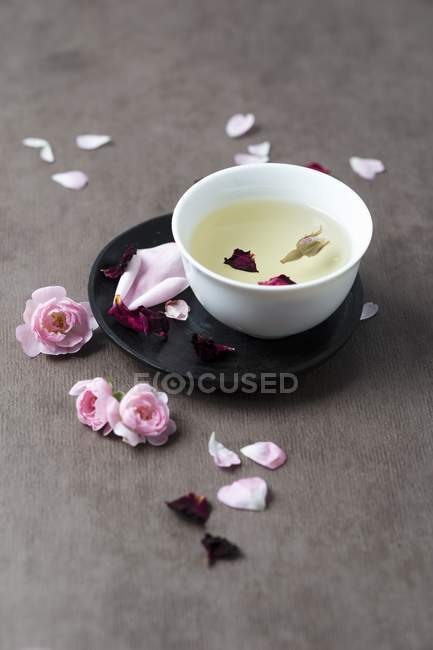 Closeup view of tea and rose petals — Stock Photo