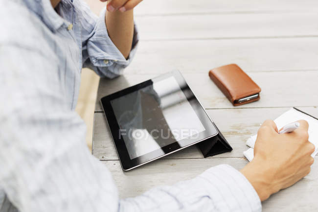 Man working on tablet at table — Stock Photo