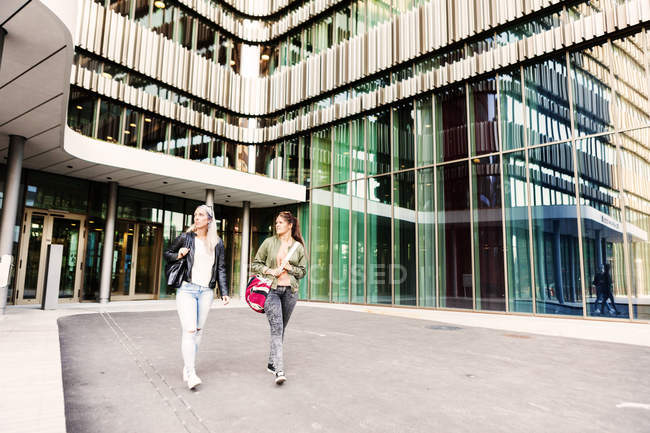 Female friends walking outside university — Stock Photo