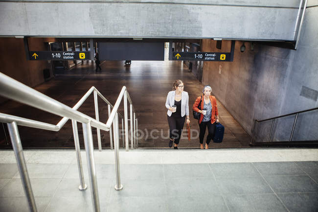 Businesswomen moving up steps at railroad station — Stock Photo