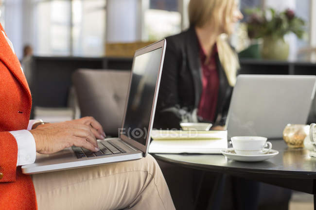 Businesswoman using laptop in meeting at restaurant — Stock Photo