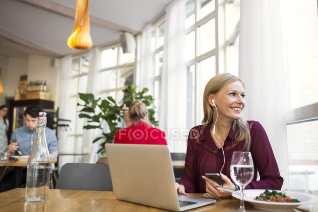 Businesswoman talking through earphones — Stock Photo