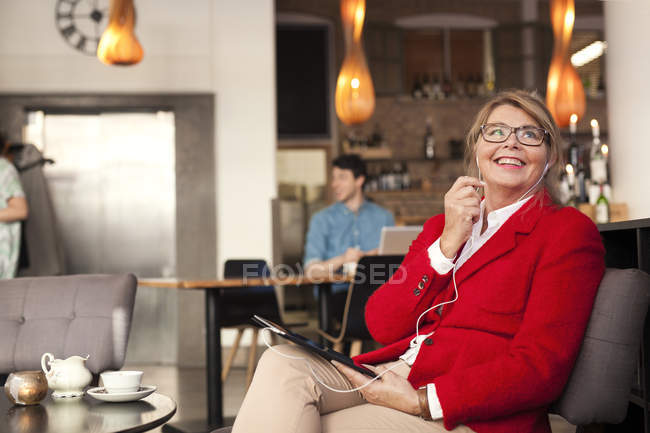 Businesswoman talking through earphones — Stock Photo