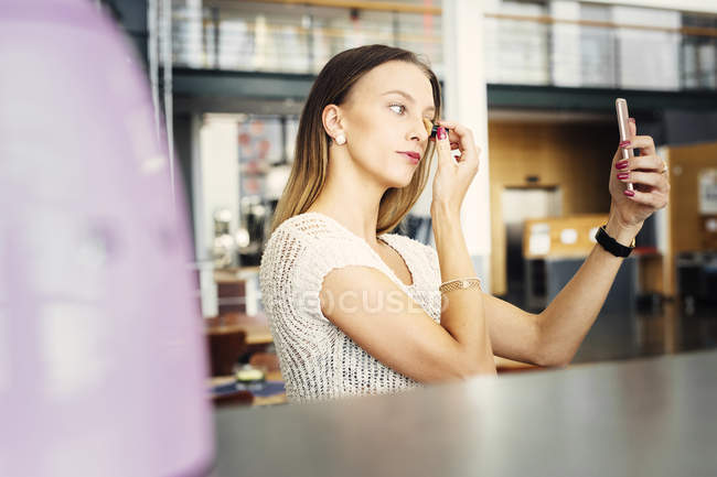 Woman correcting makeup — Stock Photo