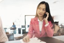 Young attractive asian woman using smartphone in shopping mall — Stock Photo