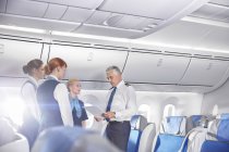 Pilot and flight attendants talking, preparing on airplane — Stock Photo