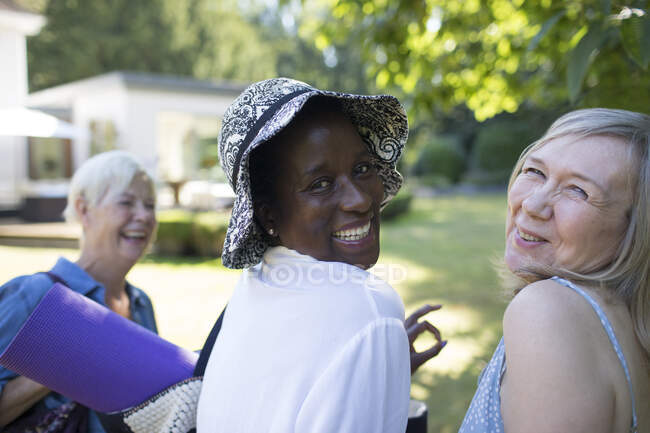 Ritratto felici amiche anziane con stuoia di yoga nel giardino estivo — Foto stock