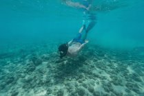 Man swimming underwater in turquoise sea — Stock Photo