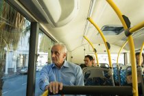 Senior man looking through window while travelling in the bus — Stock Photo