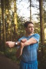 Young man stretching in the forest — Stock Photo