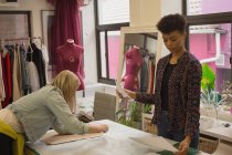 Fashion designer working on table in fashion studio — Stock Photo